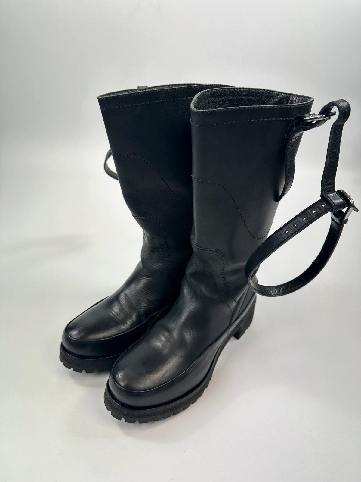 Prada black leather garter strap boots with minimalist design and original box.