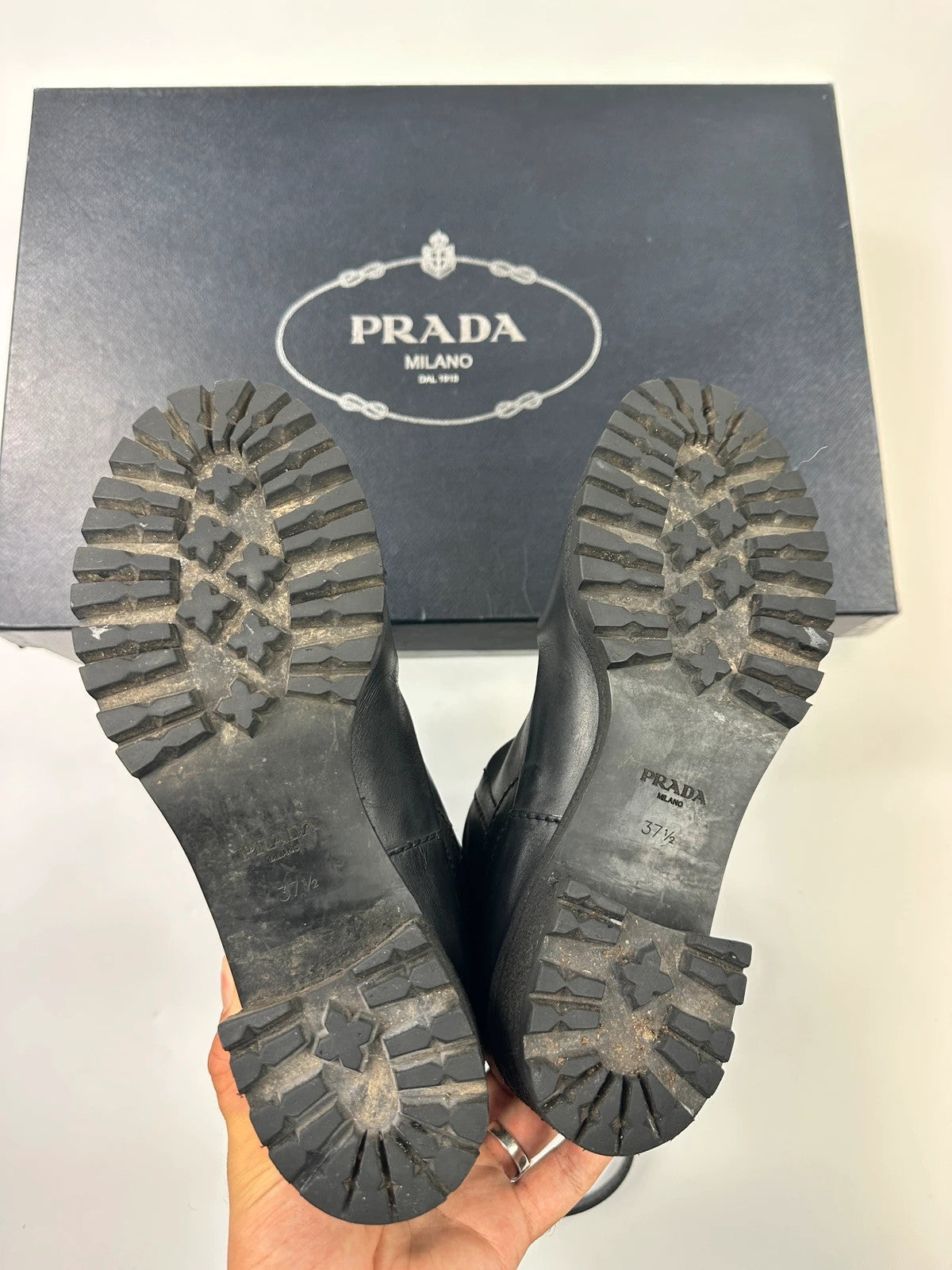 Prada black leather garter strap boots with minimalist design and original box.