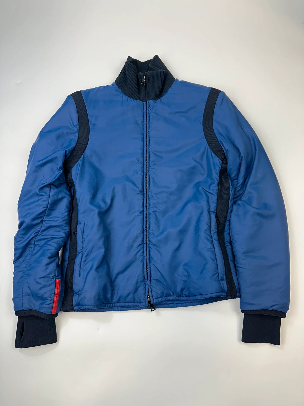 Prada blue padded nylon tech jacket with logo detail and minimalist design.