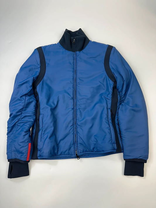 Prada blue padded nylon tech jacket with logo detail and minimalist design.