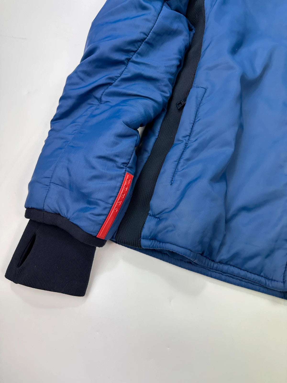 Prada blue padded nylon tech jacket with logo detail and minimalist design.