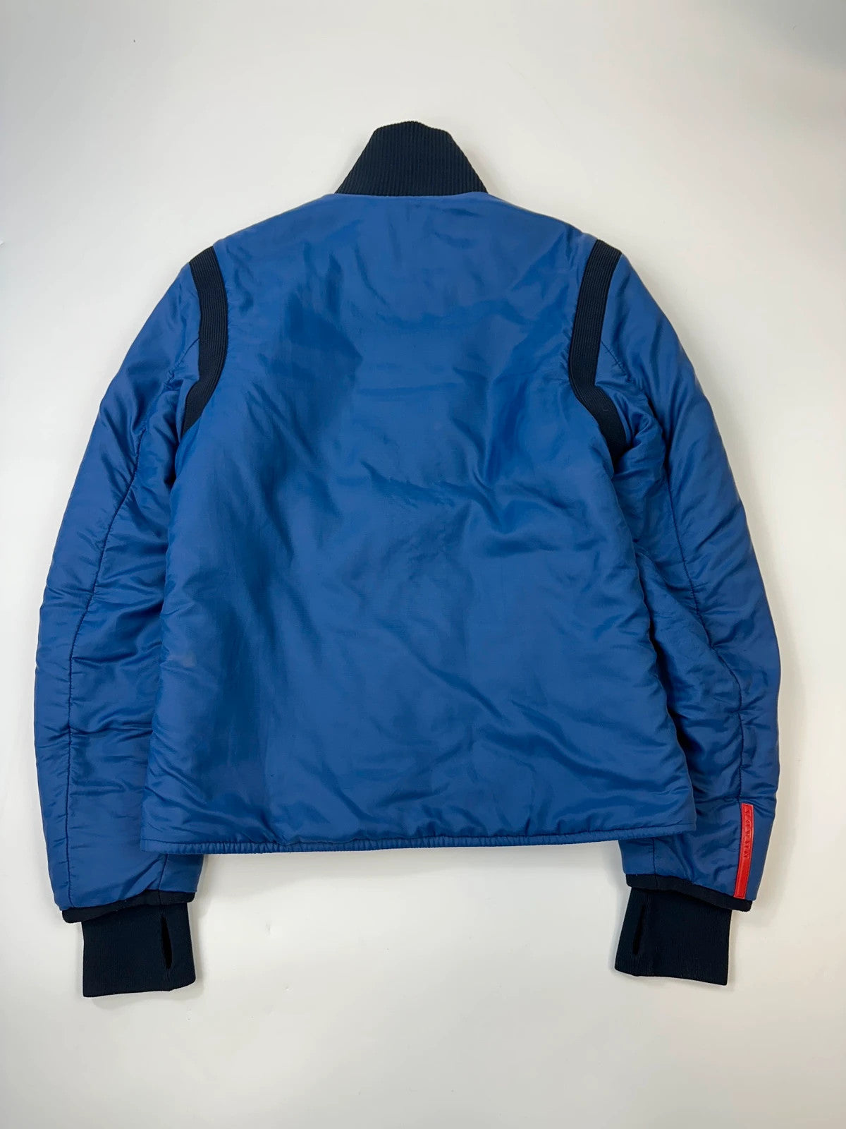 Prada blue padded nylon tech jacket with logo detail and minimalist design.