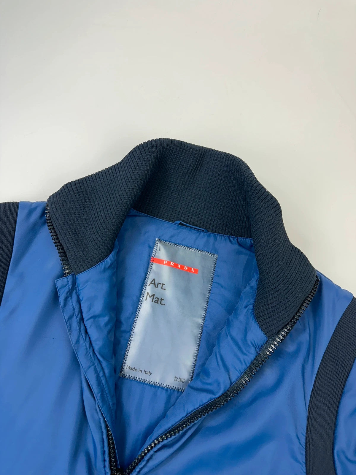 Prada blue padded nylon tech jacket with logo detail and minimalist design.