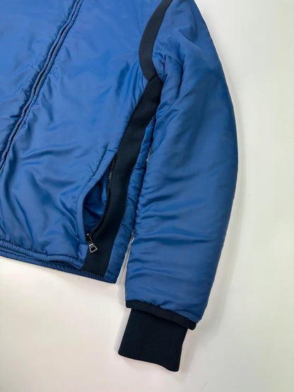 Prada blue padded nylon tech jacket with logo detail and minimalist design.
