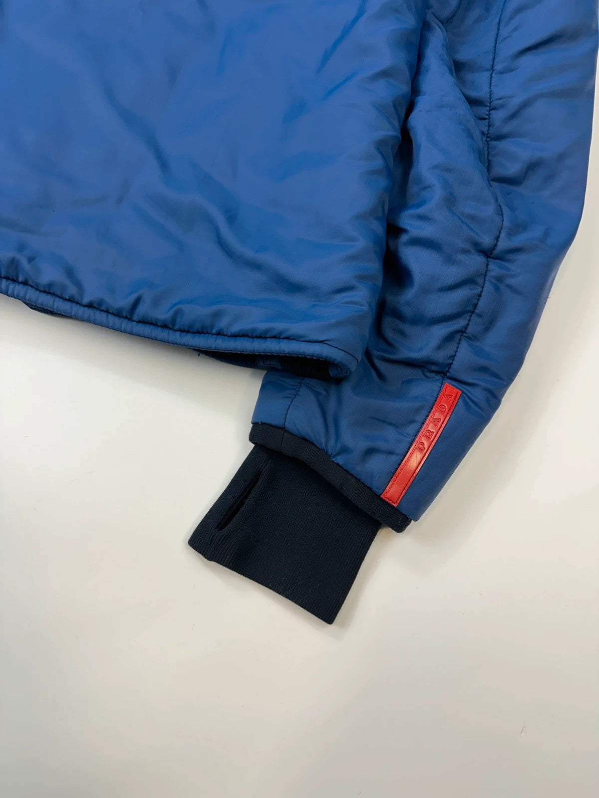 Prada blue padded nylon tech jacket with logo detail and minimalist design.