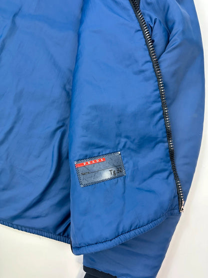 Prada blue padded nylon tech jacket with logo detail and minimalist design.