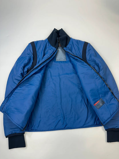 Prada blue padded nylon tech jacket with logo detail and minimalist design.