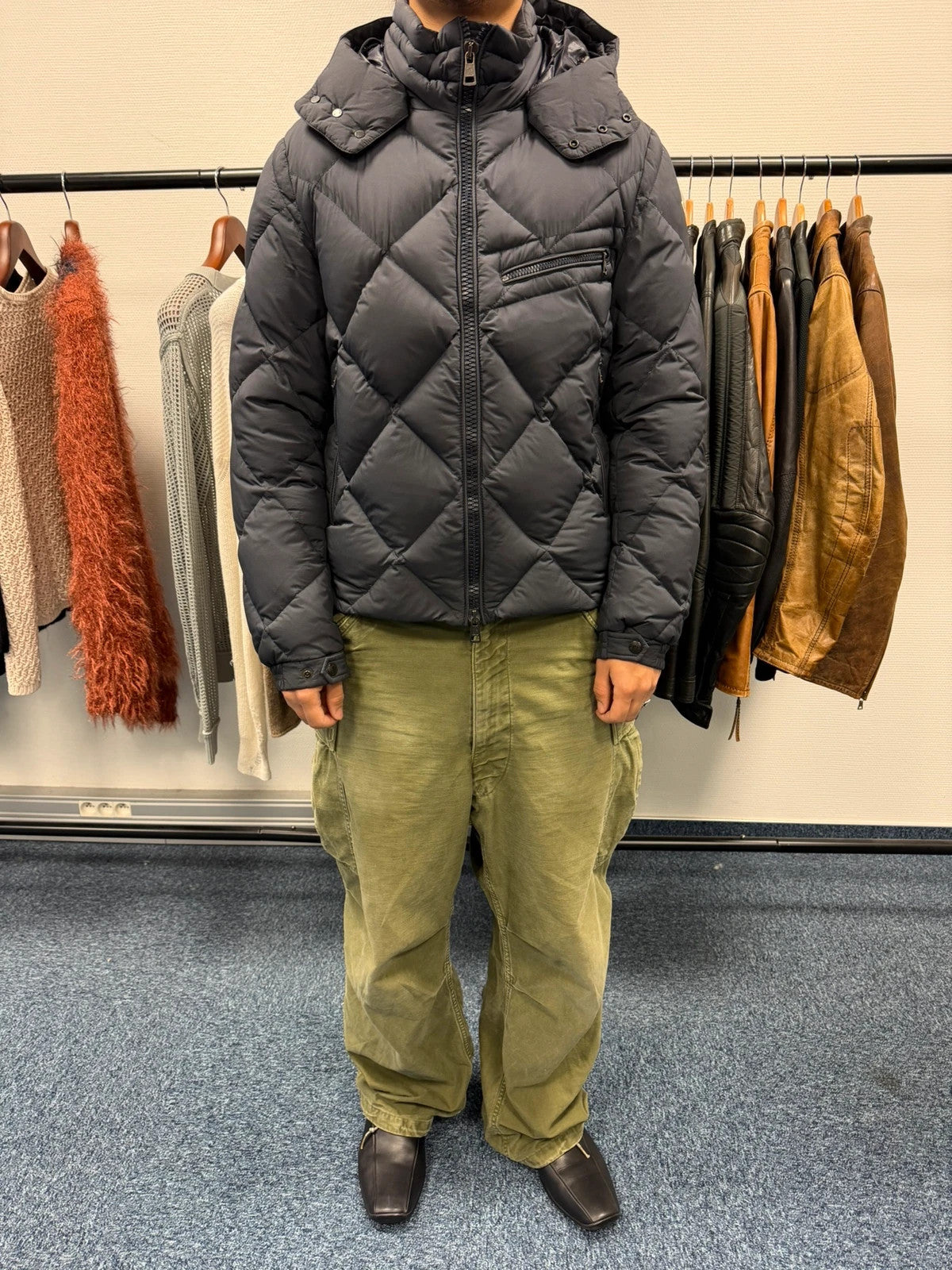 Moncler navy blue puffer jacket with diamond pattern, hood, and down filling.