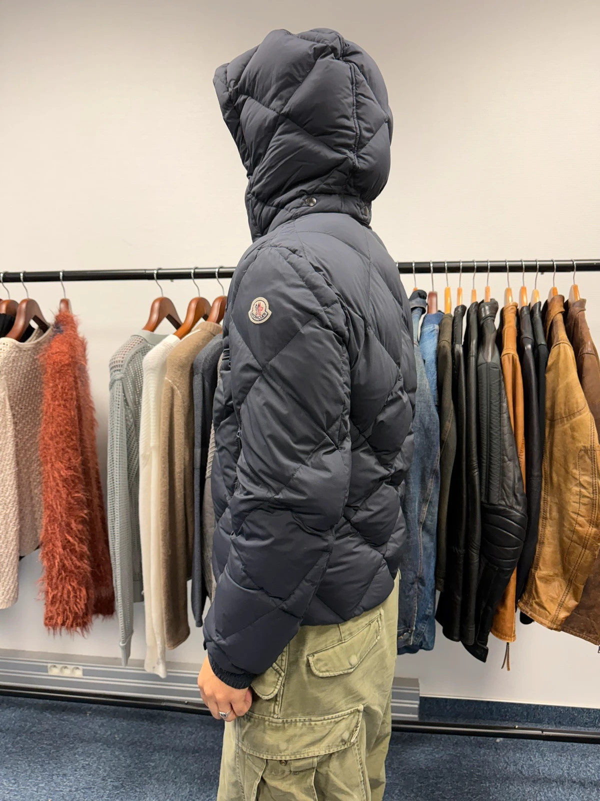 Moncler navy blue puffer jacket with diamond pattern, hood, and down filling.