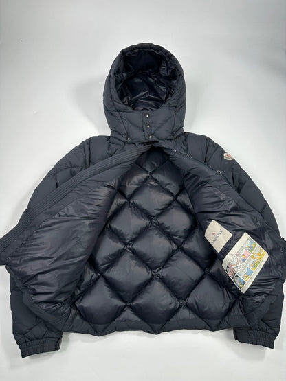 Moncler navy blue puffer jacket with diamond pattern, hood, and down filling.