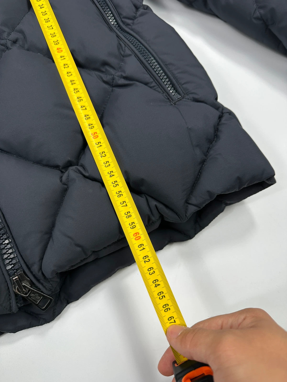 Moncler navy blue puffer jacket with diamond pattern, hood, and down filling.