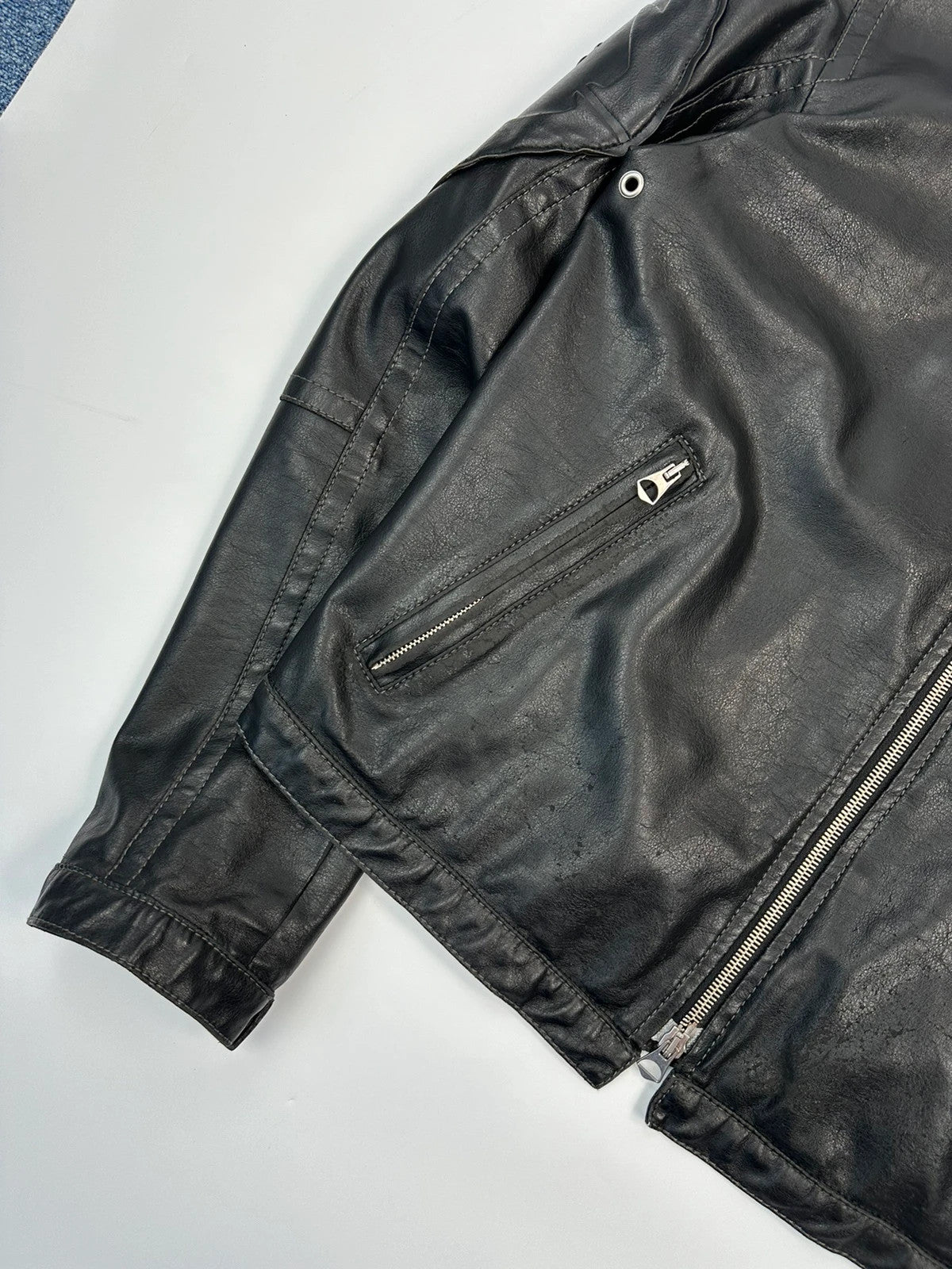Armani Jeans black faux leather jacket with worn pockets and minimalist design.