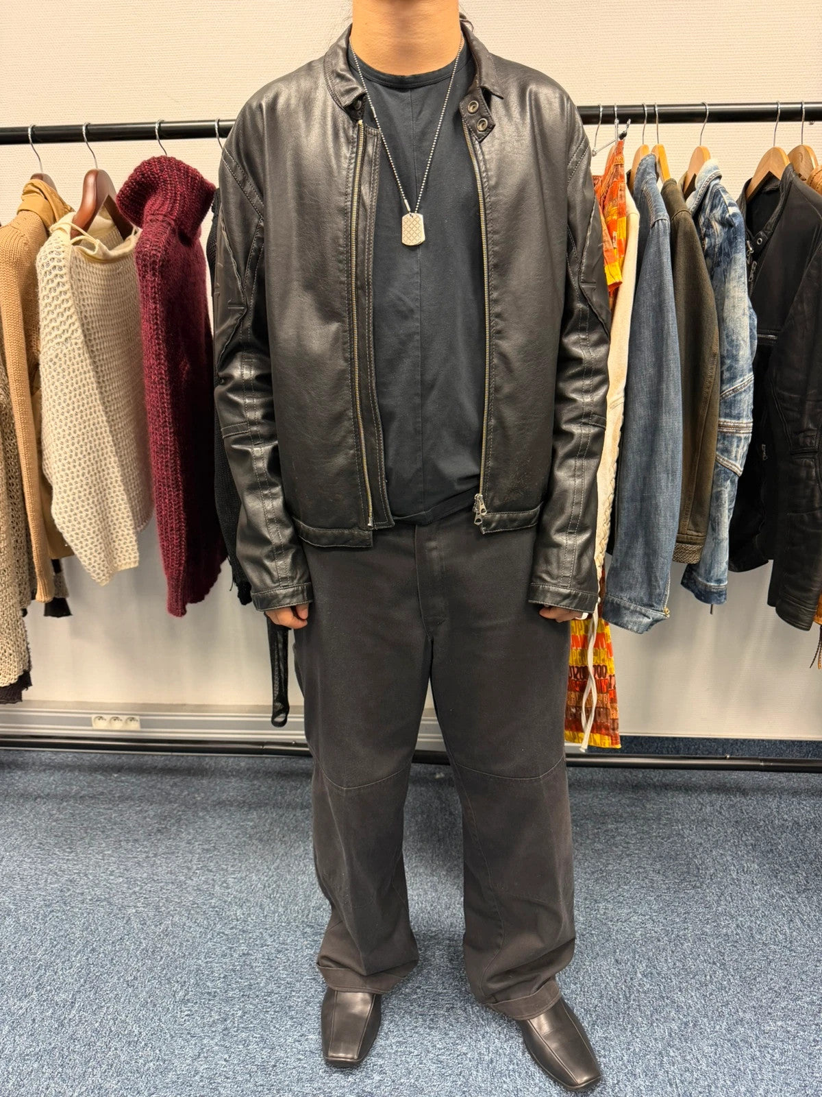 Armani Jeans black faux leather jacket with worn pockets and minimalist design.