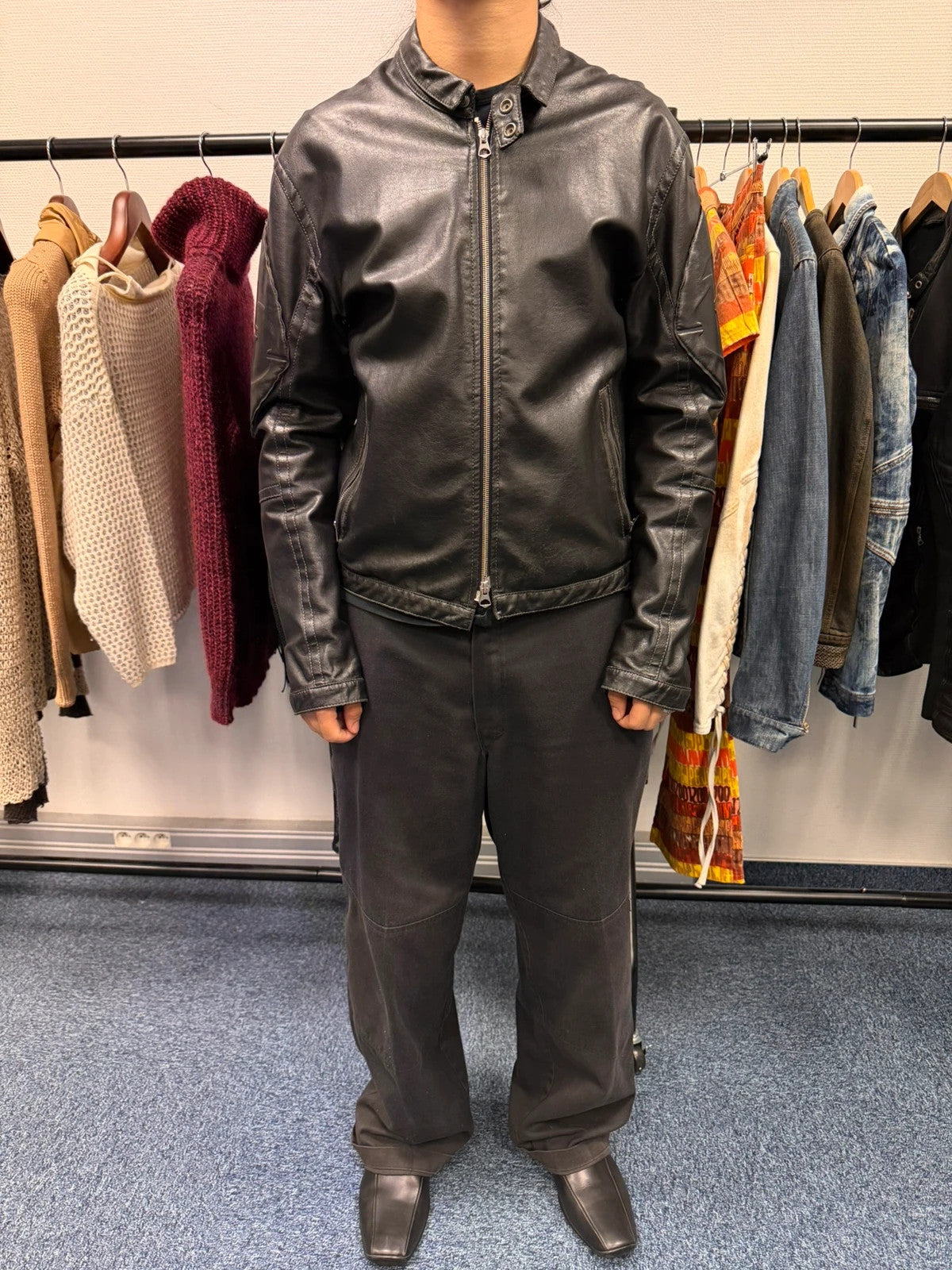 Armani Jeans black faux leather jacket with worn pockets and minimalist design.