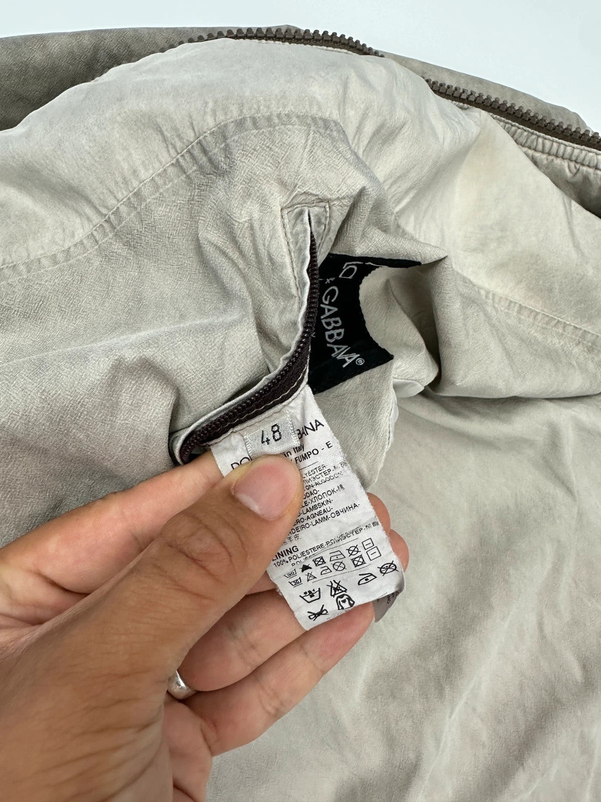 Dolce & Gabbana beige grey bomber jacket with faded nylon and logo details.