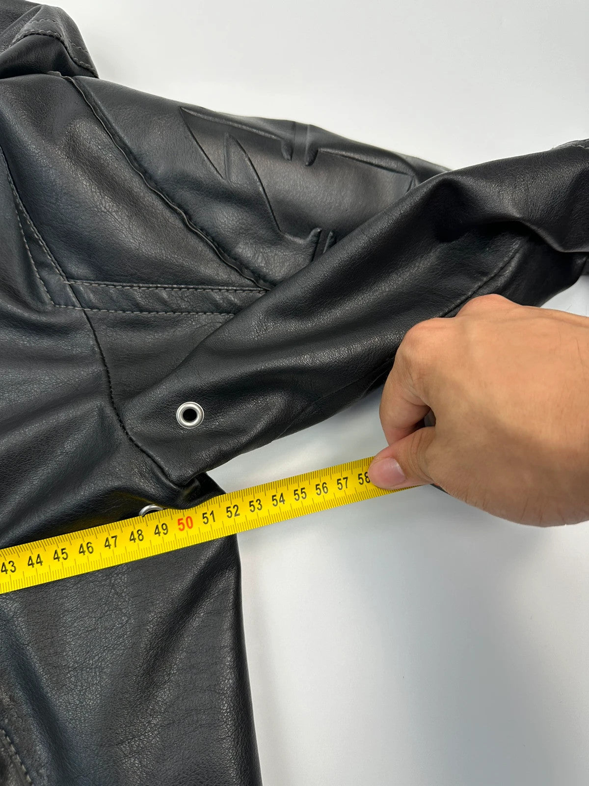 Armani Jeans black faux leather jacket with worn pockets and minimalist design.