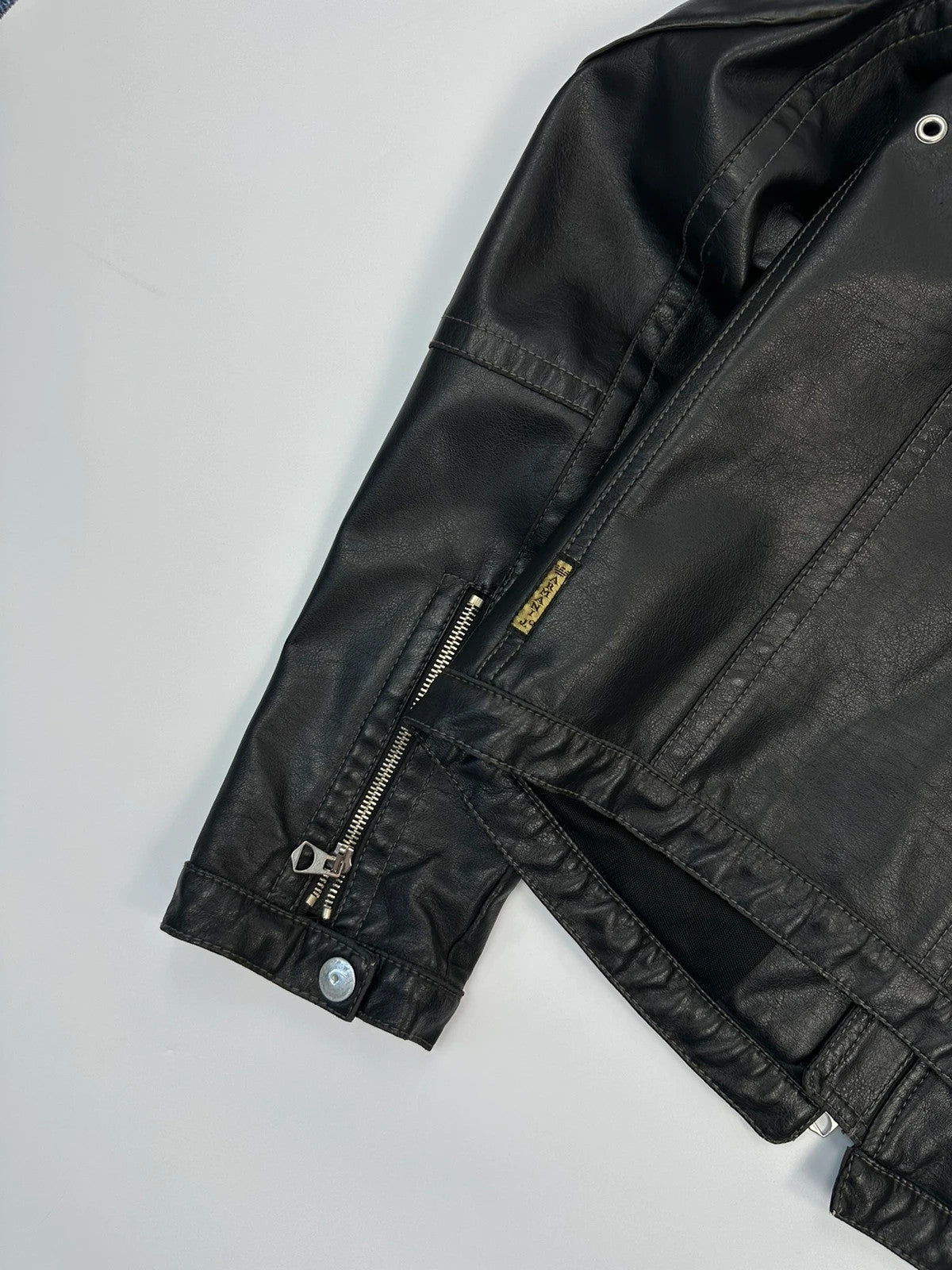 Armani Jeans black faux leather jacket with worn pockets and minimalist design.
