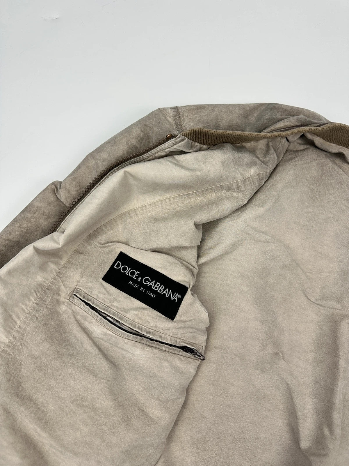 Dolce & Gabbana beige grey bomber jacket with faded nylon and logo details.