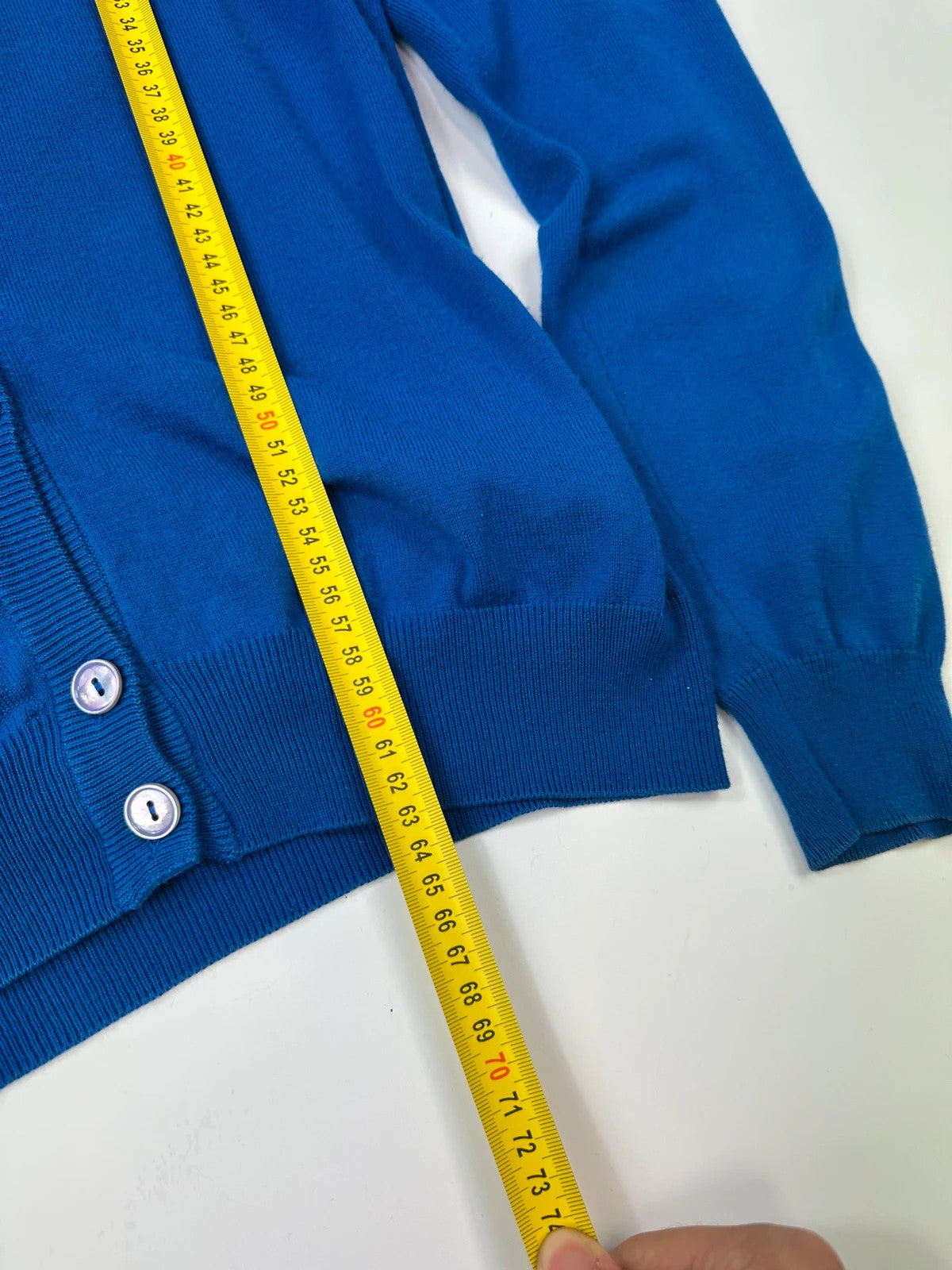 Maison Margiela electric blue cardigan with shoulder holes, minimalist design, soft knit material.