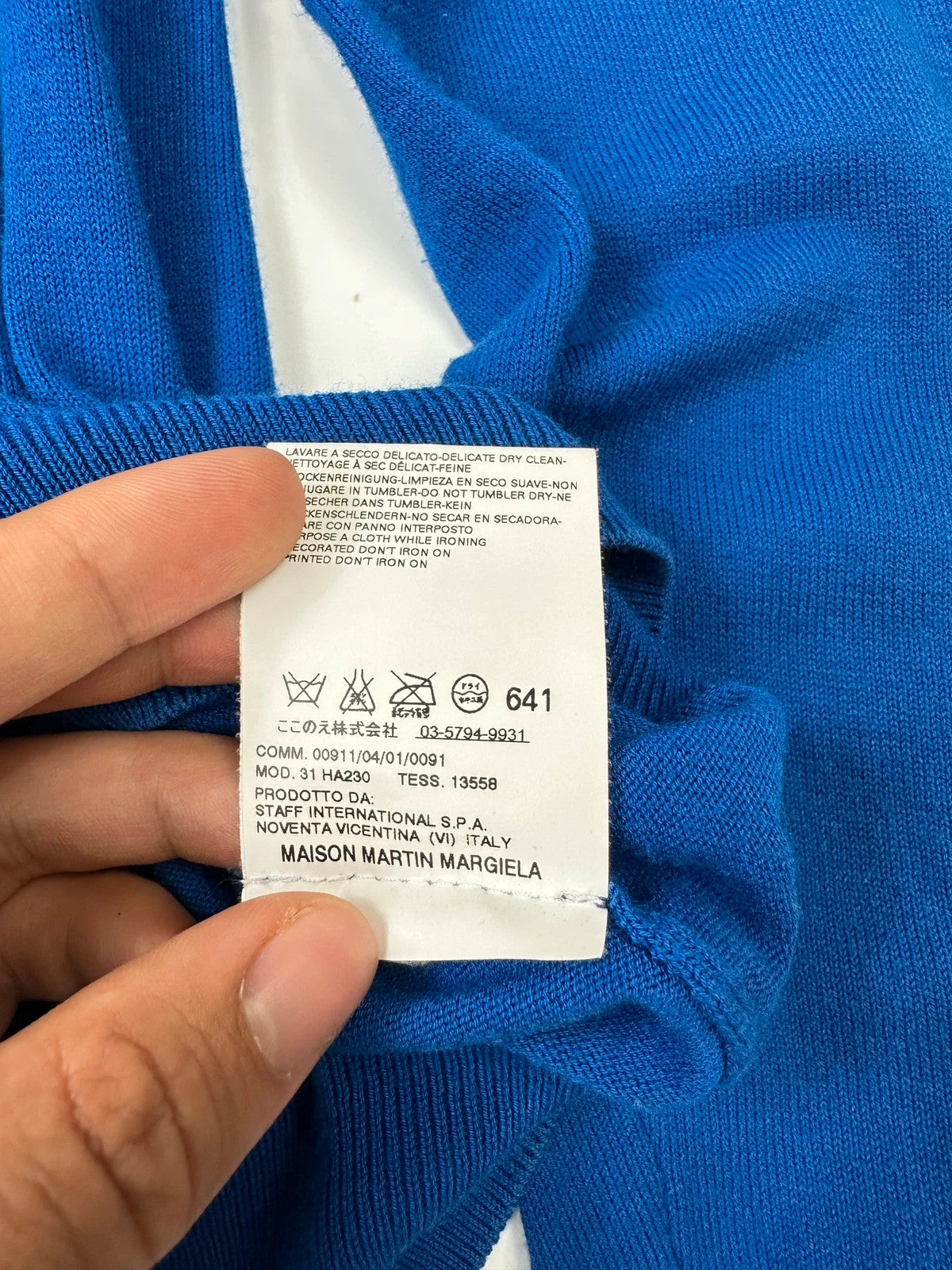 Maison Margiela electric blue cardigan with shoulder holes, minimalist design, soft knit material.