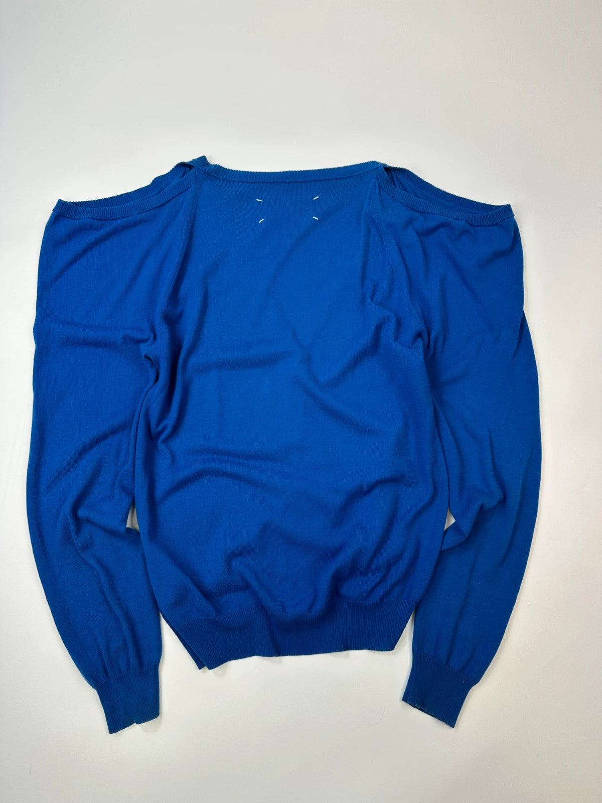 Maison Margiela electric blue cardigan with shoulder holes, minimalist design, soft knit material.