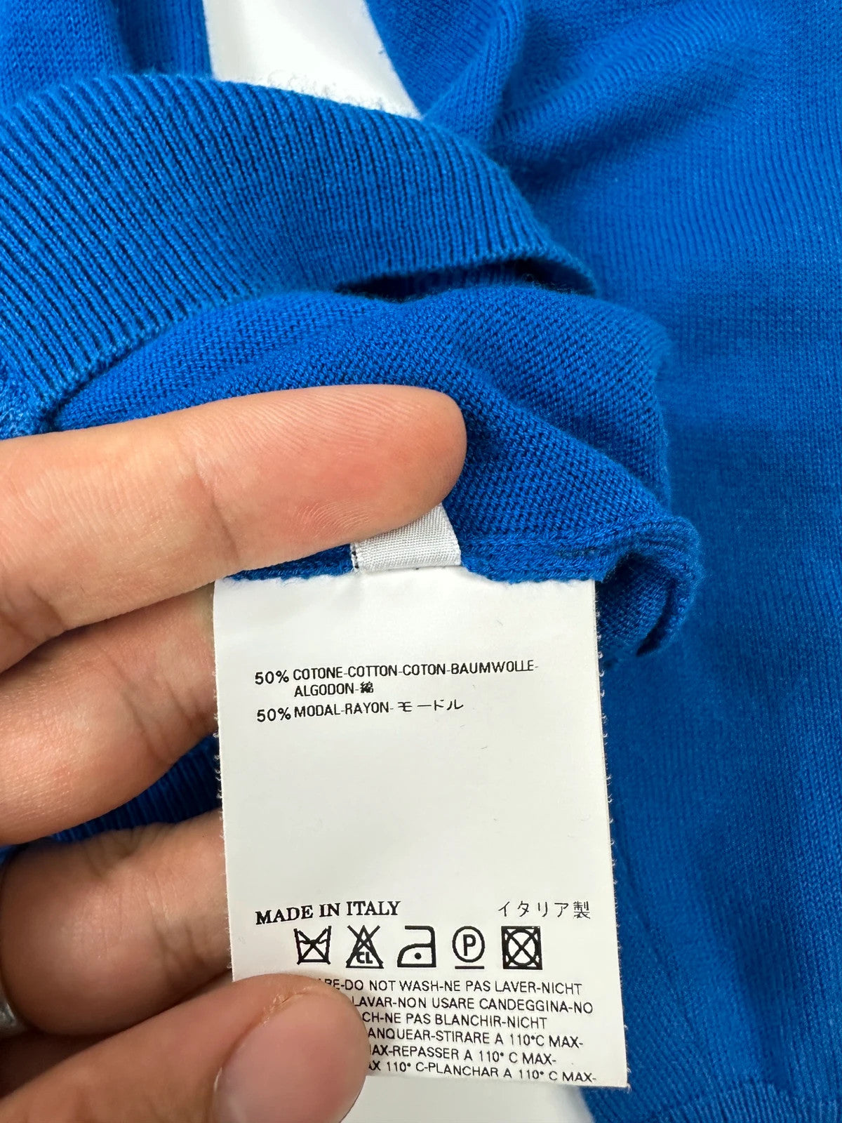 Maison Margiela electric blue cardigan with shoulder holes, minimalist design, soft knit material.