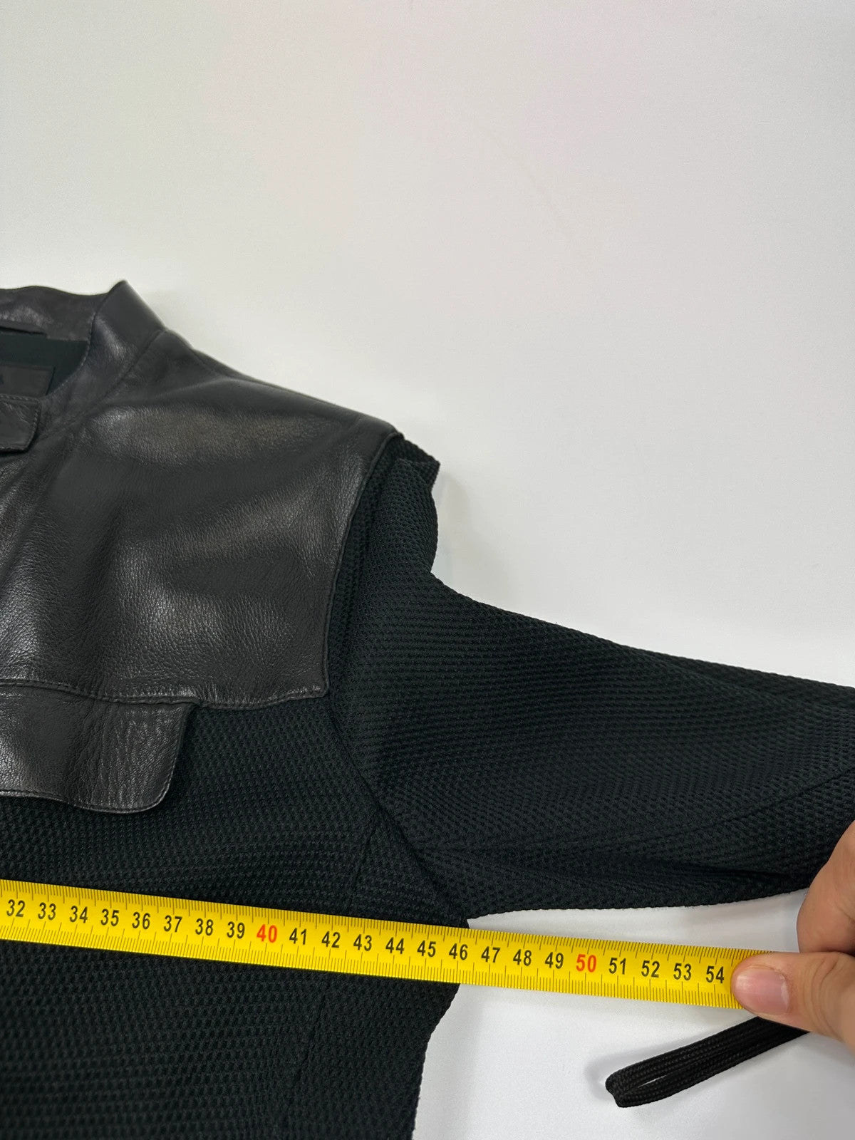 Prada black mesh and leather jacket with logo detailing and vintage design elements.