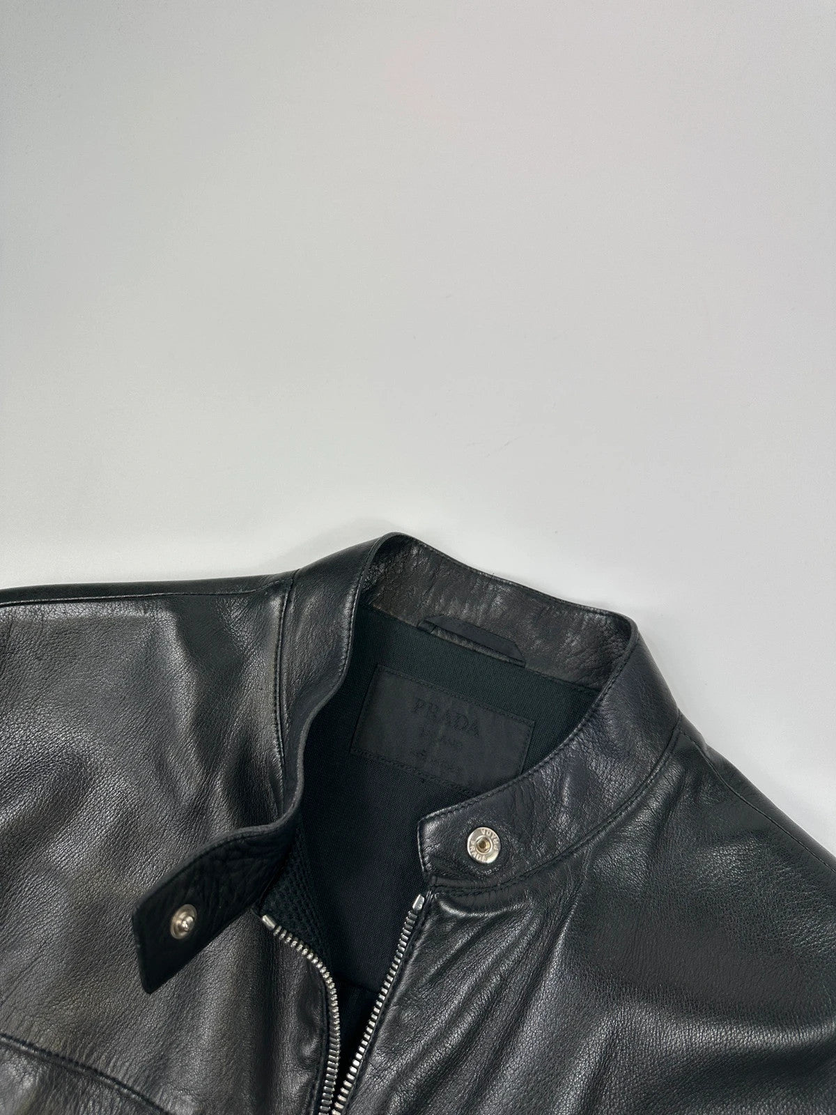 Prada black mesh and leather jacket with logo detailing and vintage design elements.