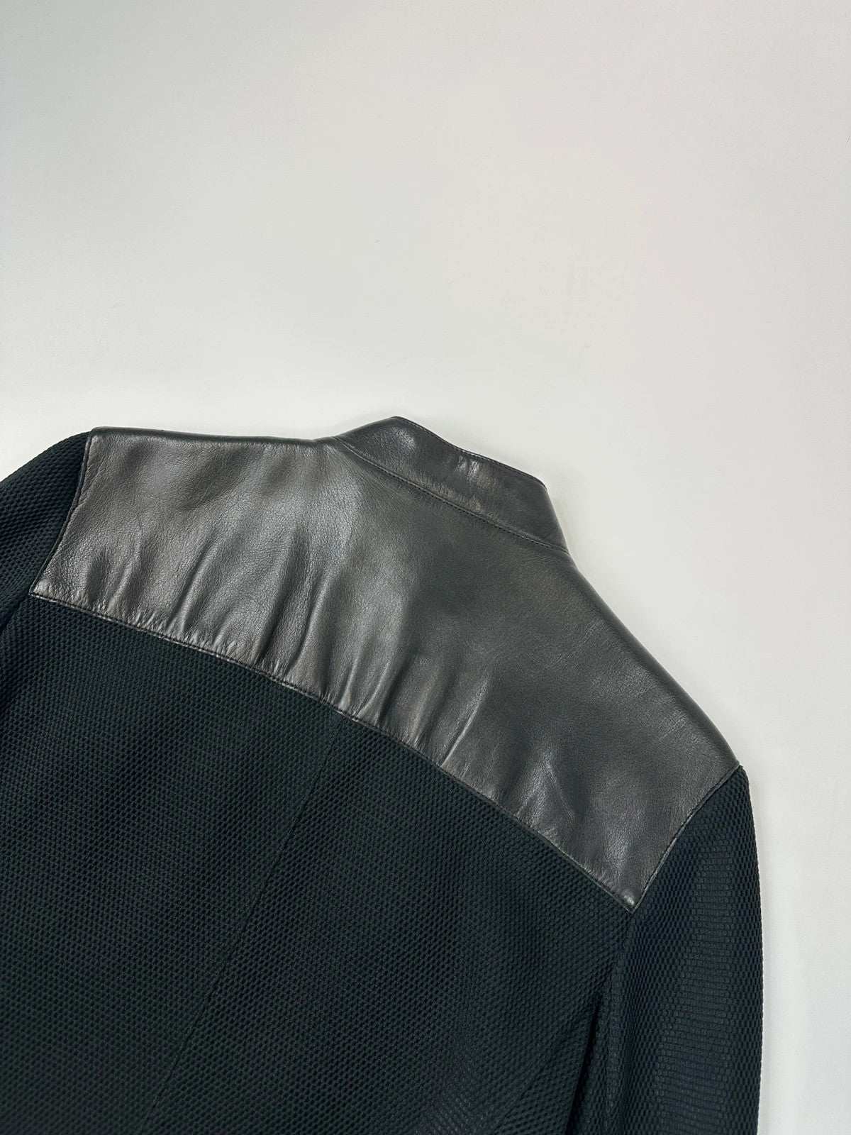 Prada black mesh and leather jacket with logo detailing and vintage design elements.
