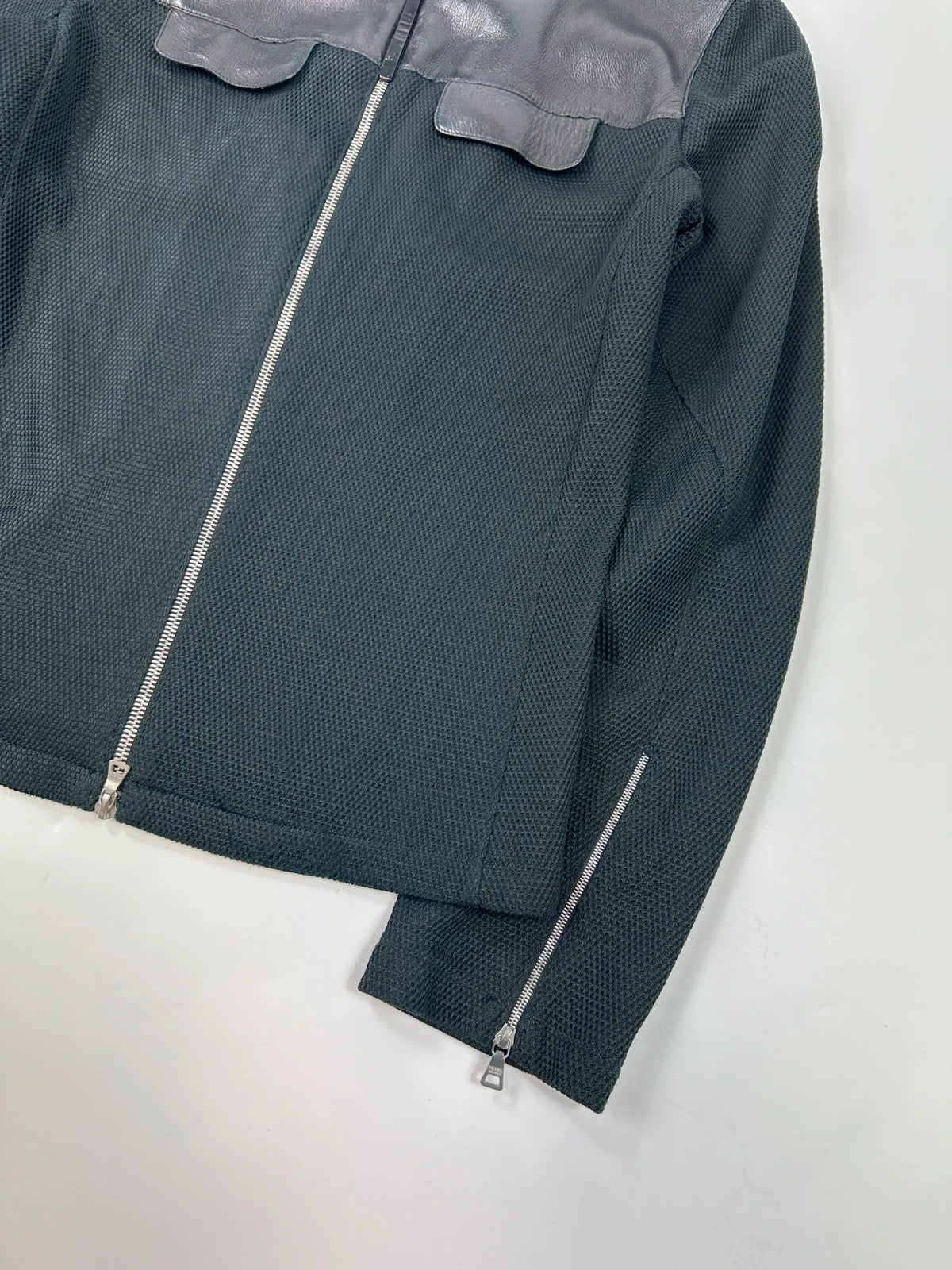 Prada black mesh and leather jacket with logo detailing and vintage design elements.