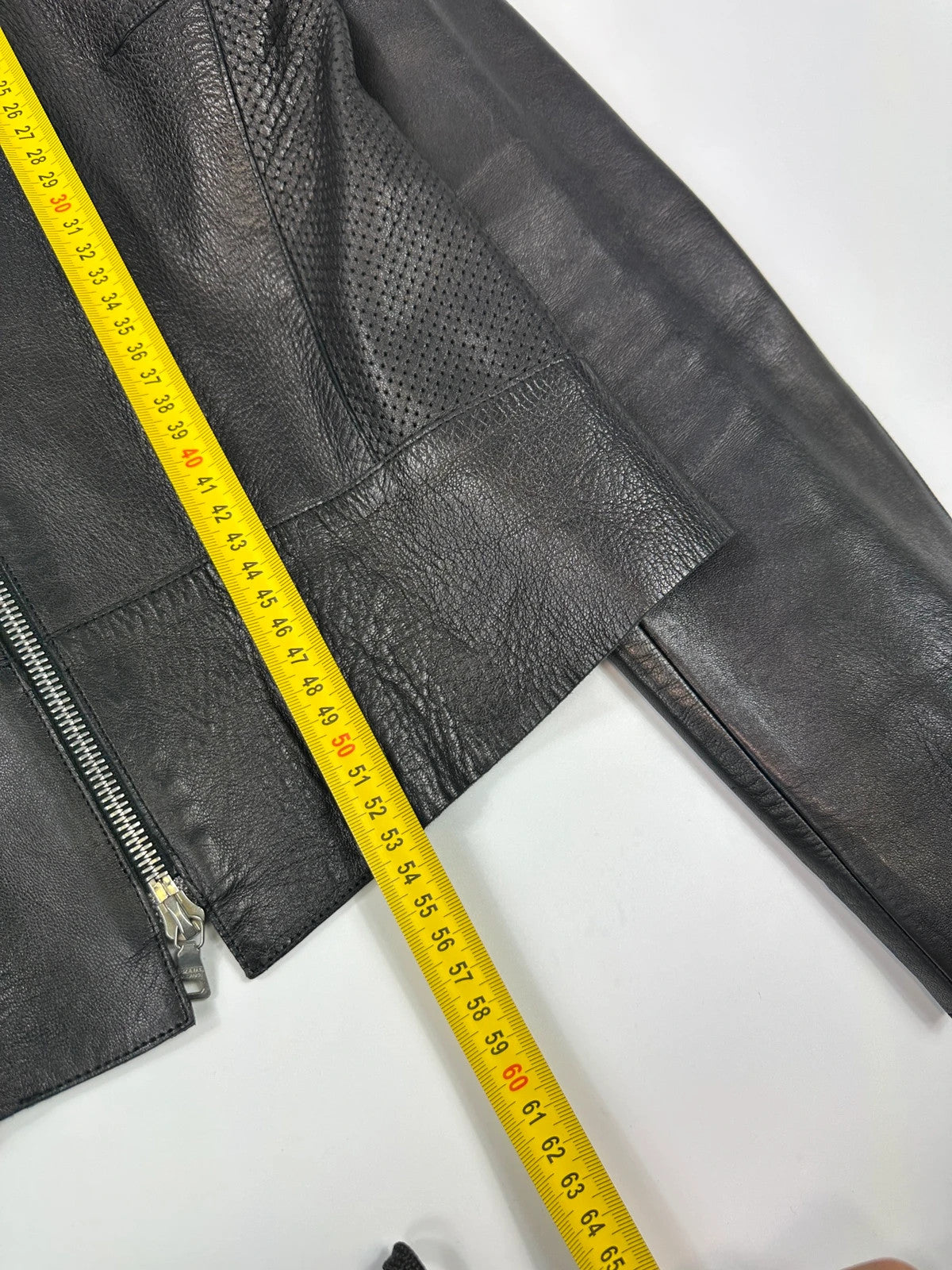 Prada black perforated leather jacket with subtle logo detailing and minimalist design.