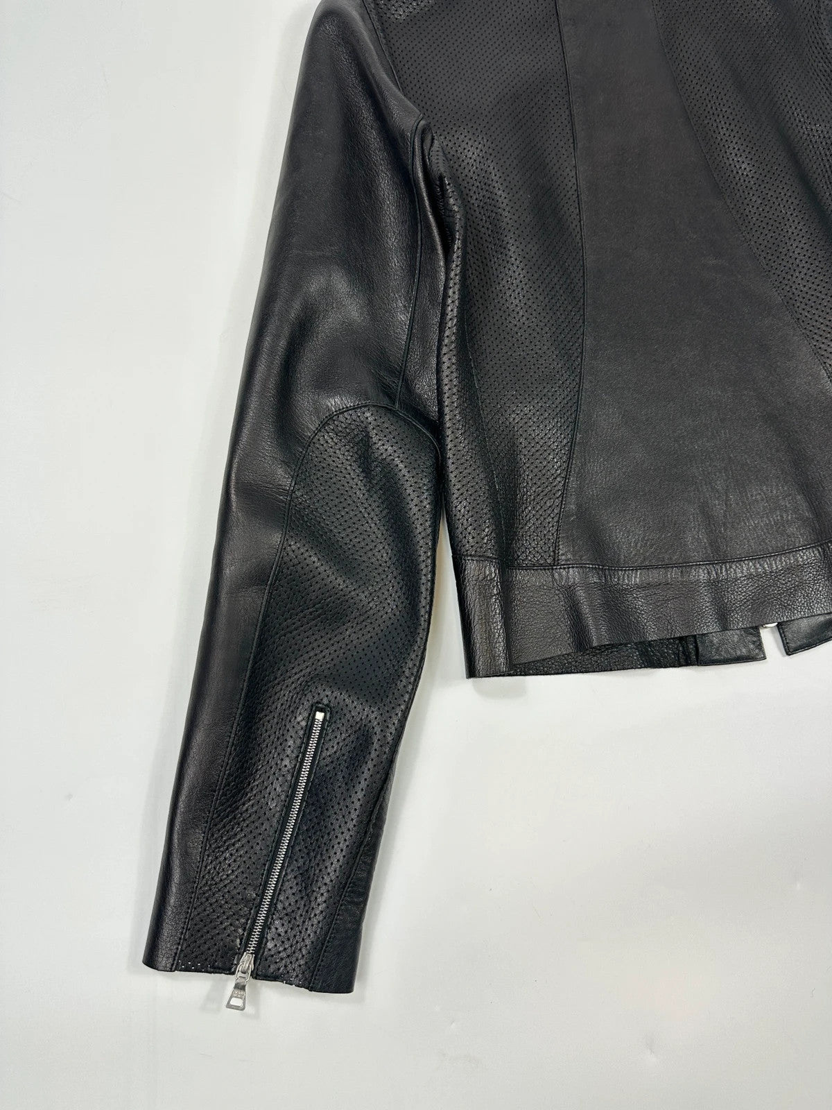 Prada black perforated leather jacket with subtle logo detailing and minimalist design.