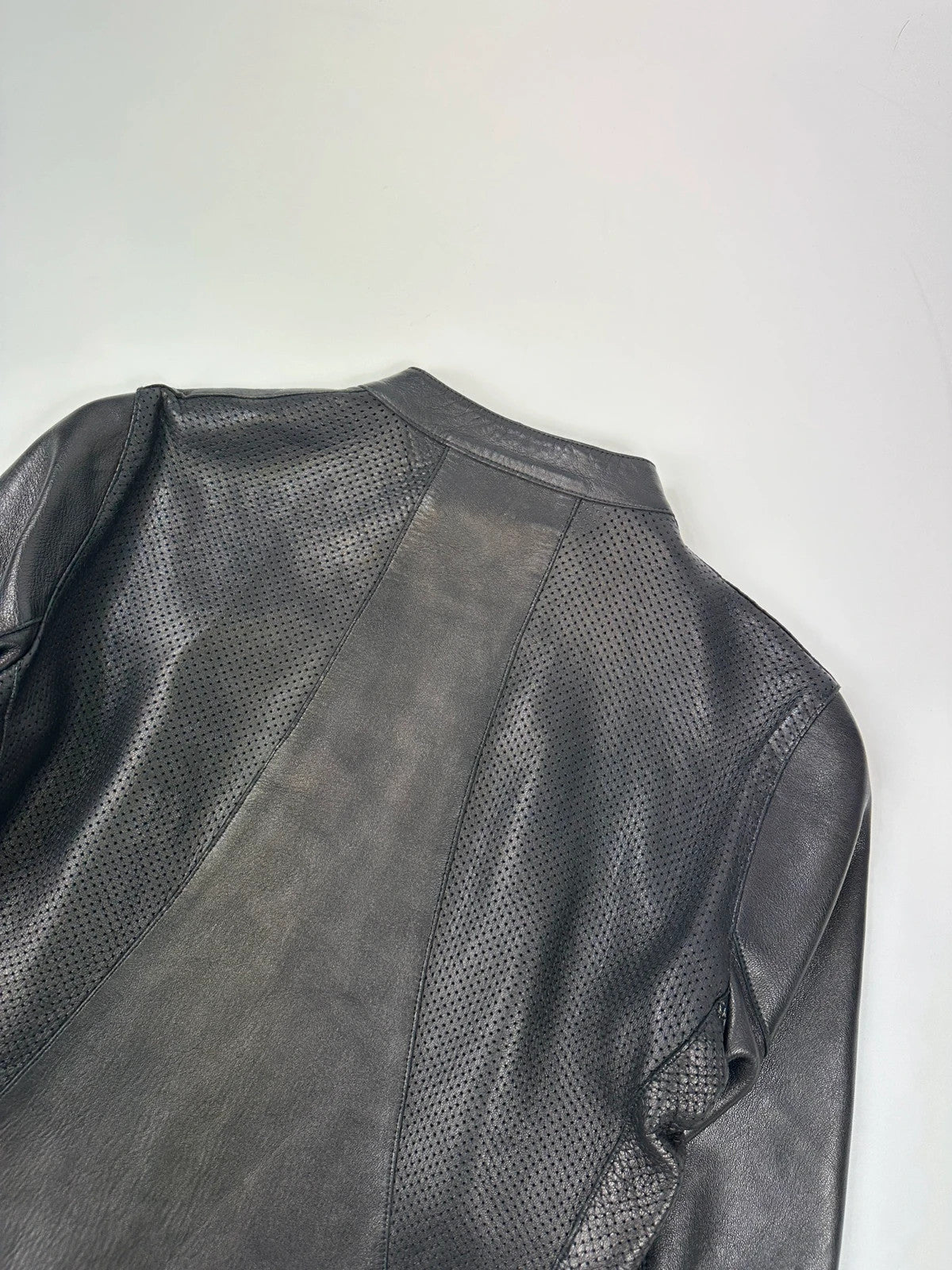 Prada black perforated leather jacket with subtle logo detailing and minimalist design.