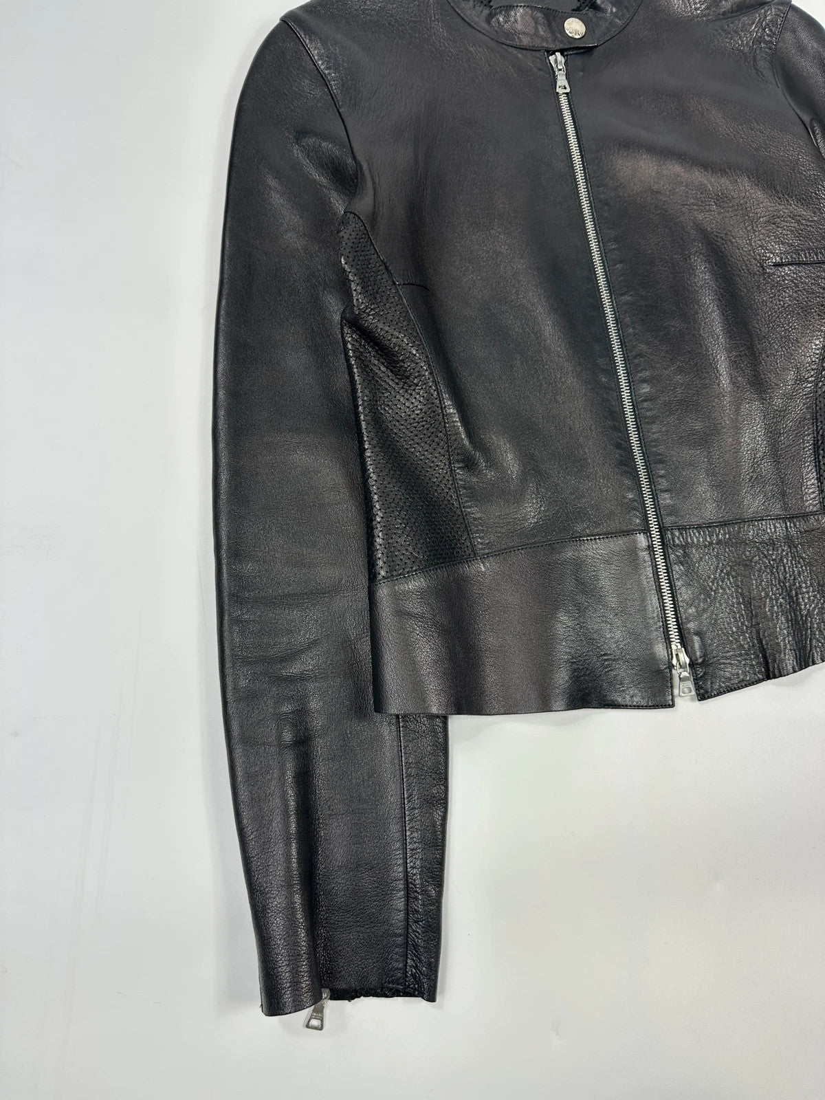 Prada black perforated leather jacket with subtle logo detailing and minimalist design.