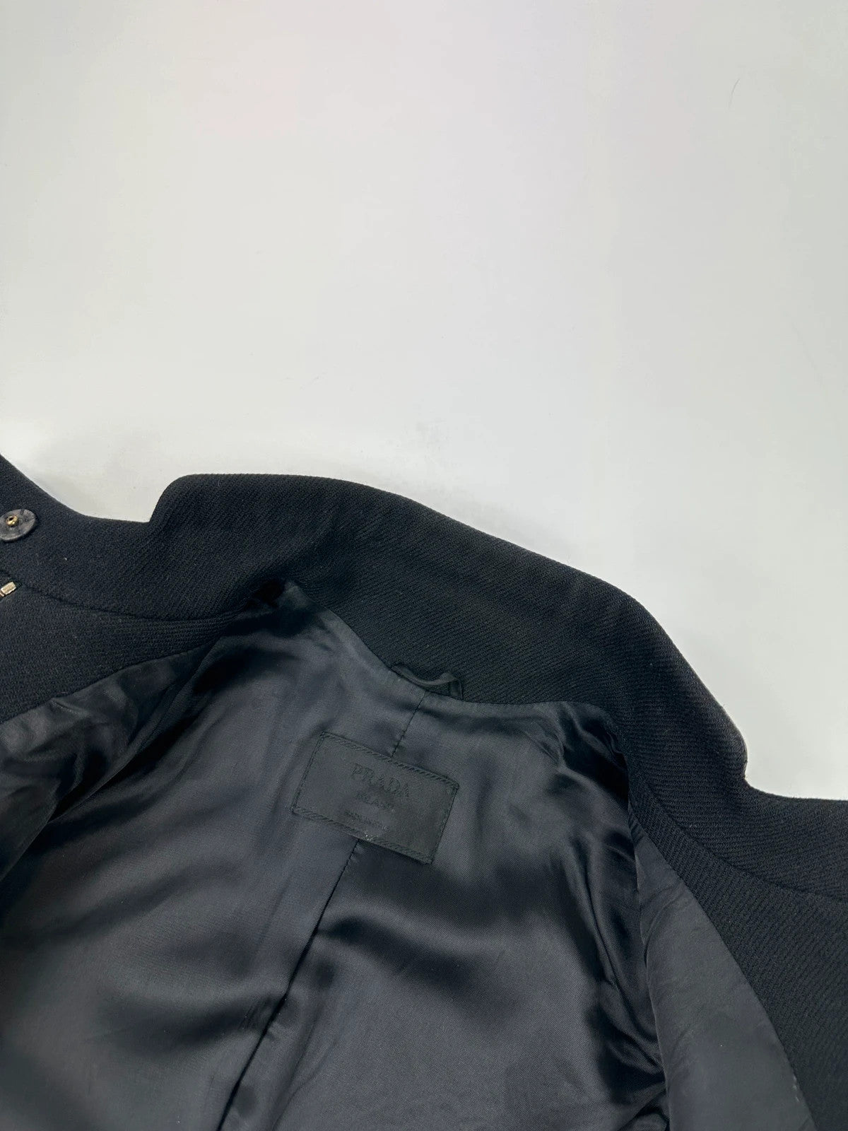Prada black wool and leather jacket with biker-style detailing and logo accents.