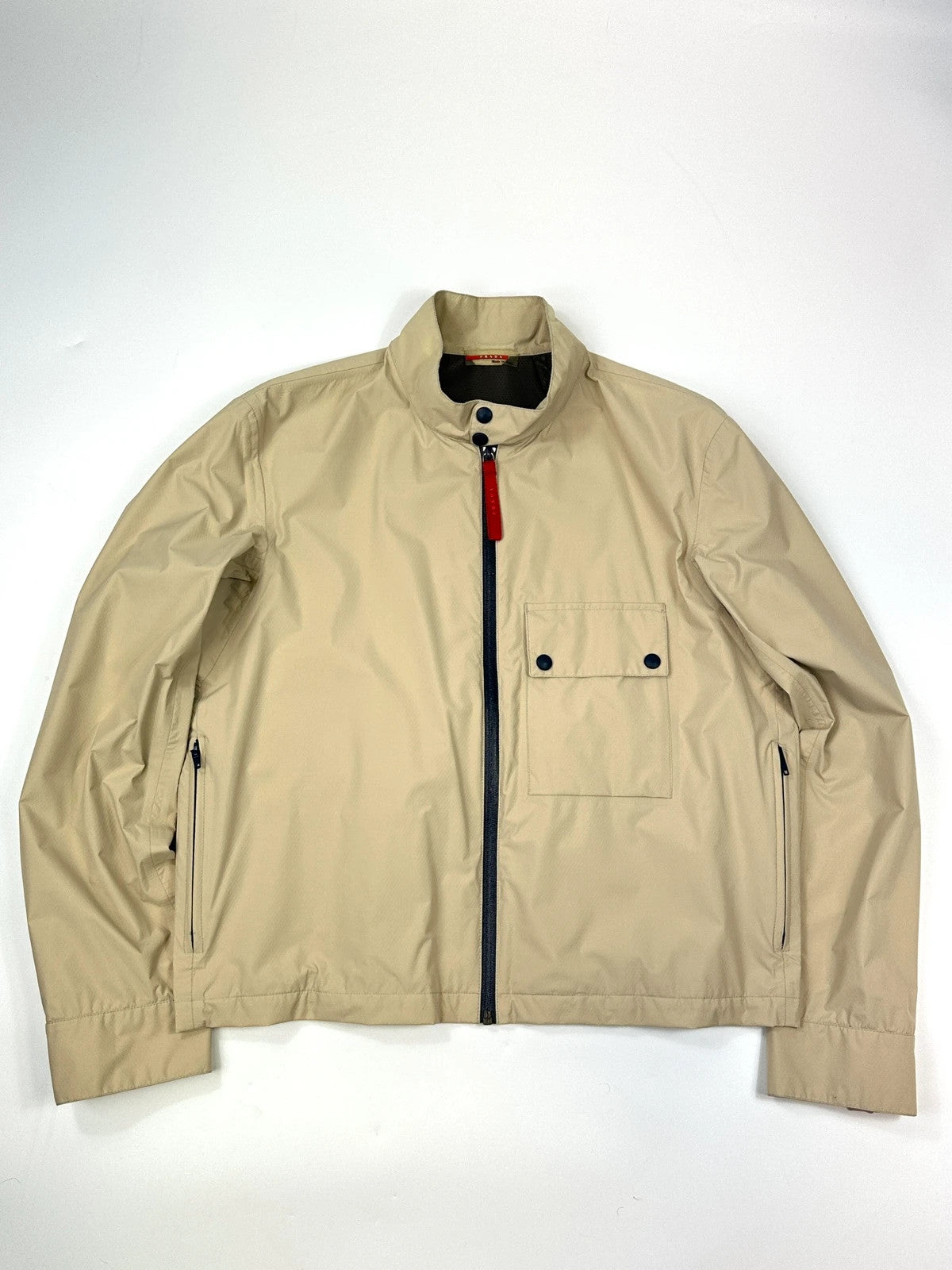 Prada beige Gore-Tex jacket packable into pocket, features logo and nylon material.