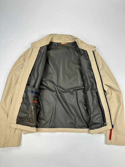 Prada beige Gore-Tex jacket packable into pocket, features logo and nylon material.