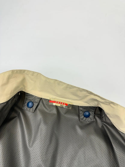 Prada beige Gore-Tex jacket packable into pocket, features logo and nylon material.