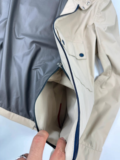 Prada beige Gore-Tex jacket packable into pocket, features logo and nylon material.