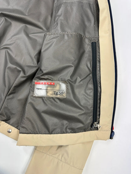 Prada beige Gore-Tex jacket packable into pocket, features logo and nylon material.