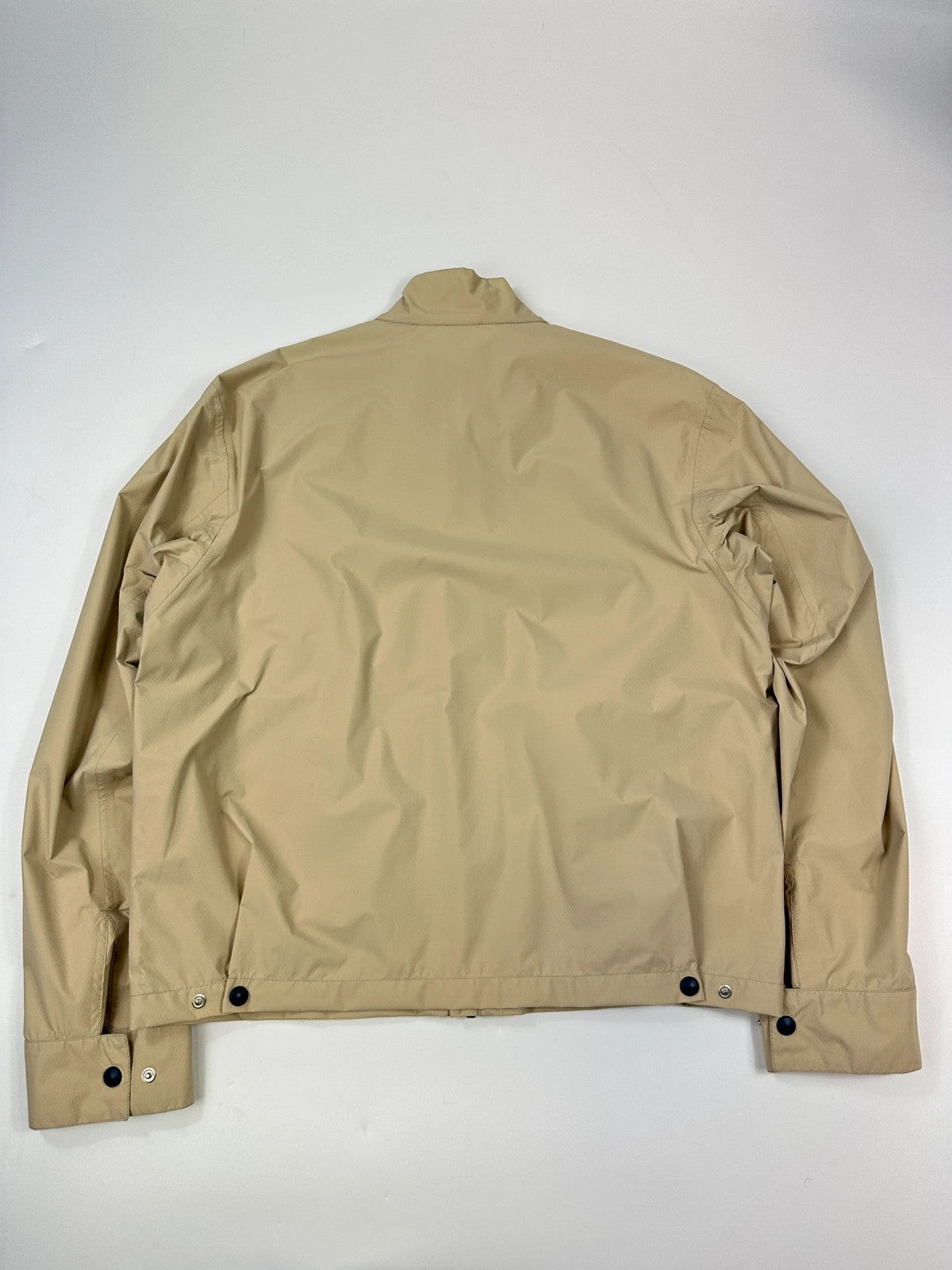 Prada beige Gore-Tex jacket packable into pocket, features logo and nylon material.