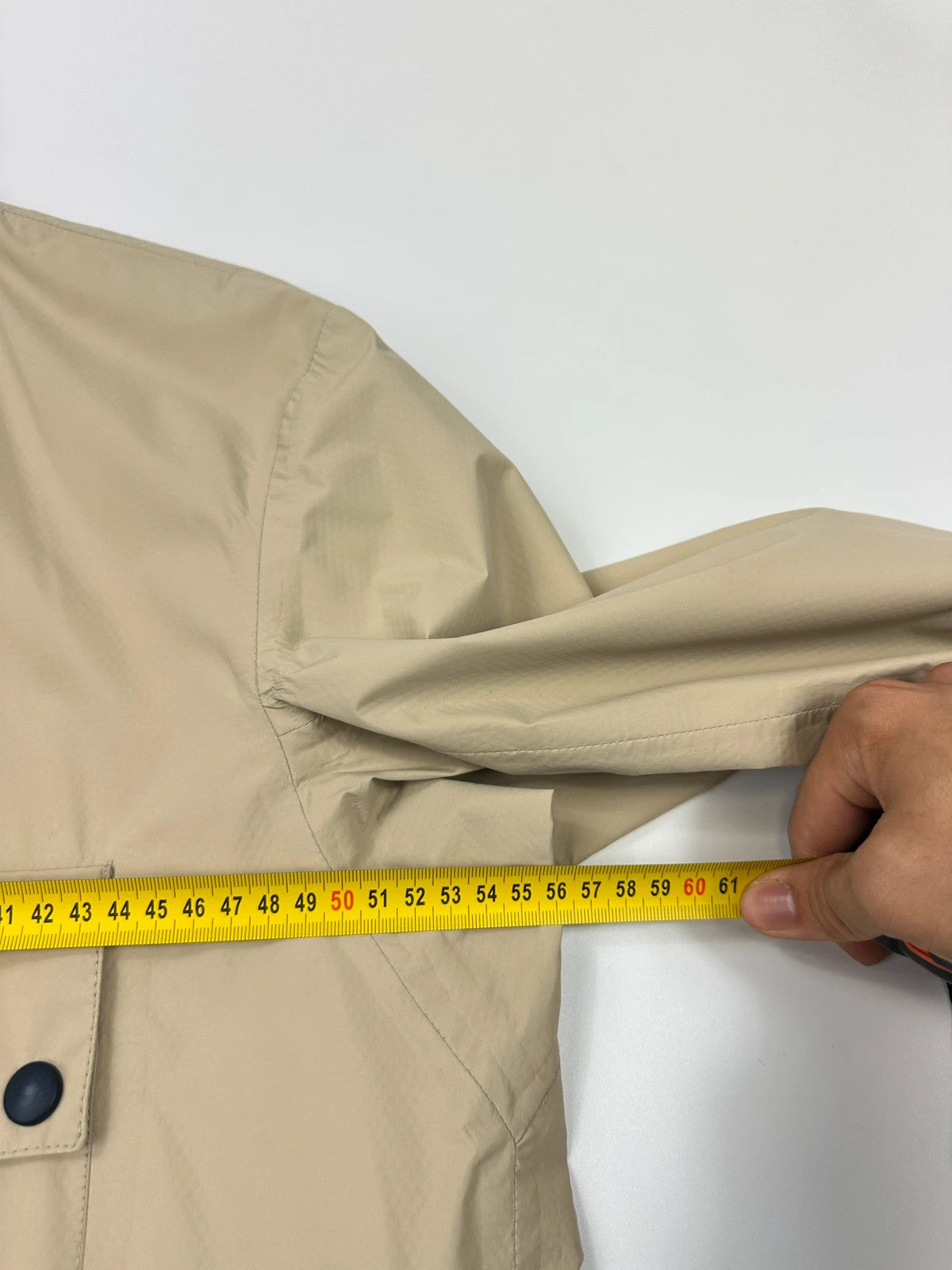 Prada beige Gore-Tex jacket packable into pocket, features logo and nylon material.