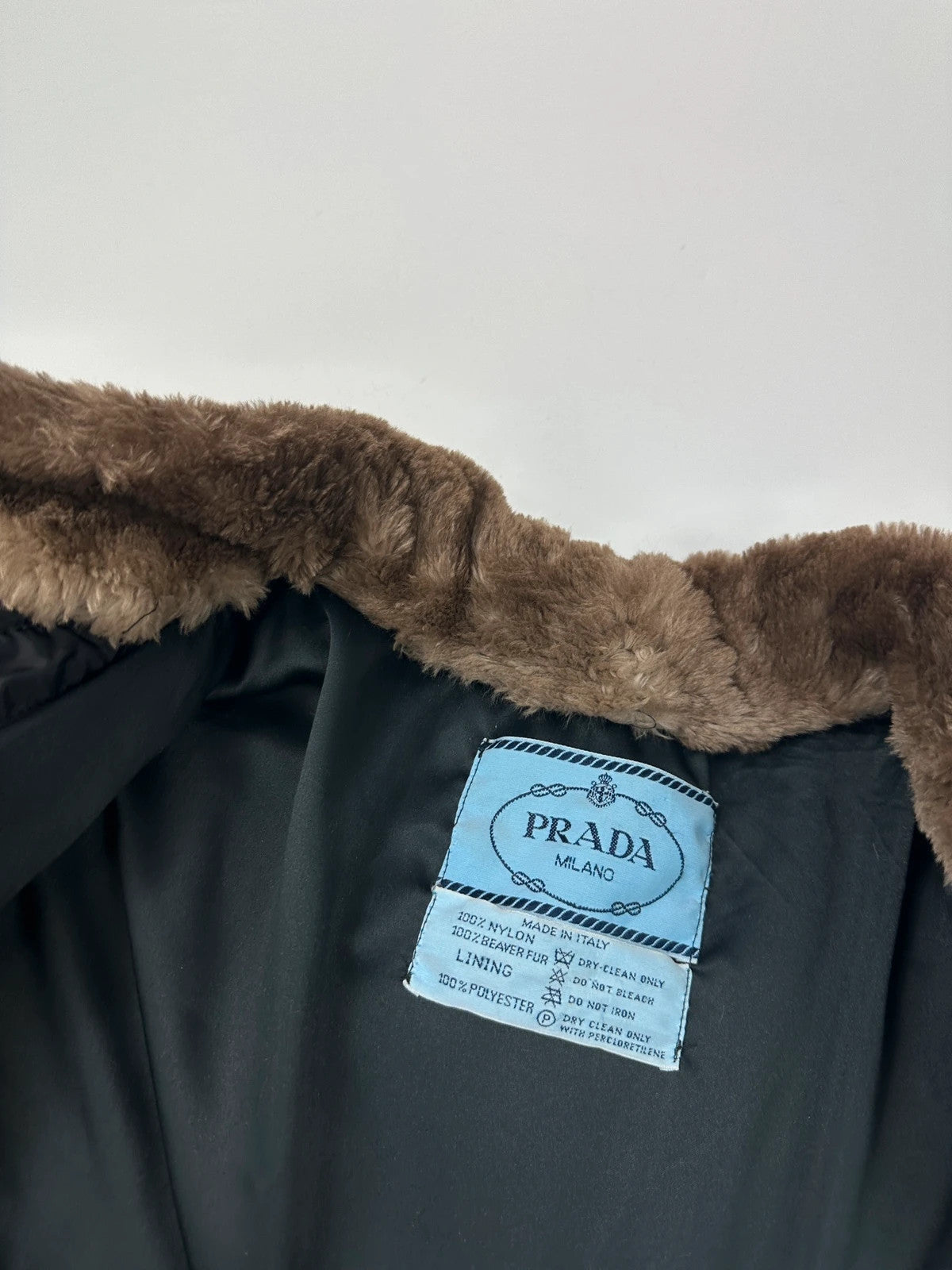 Prada black cropped bomber puffer jacket with logo detailing and vintage 90s design.