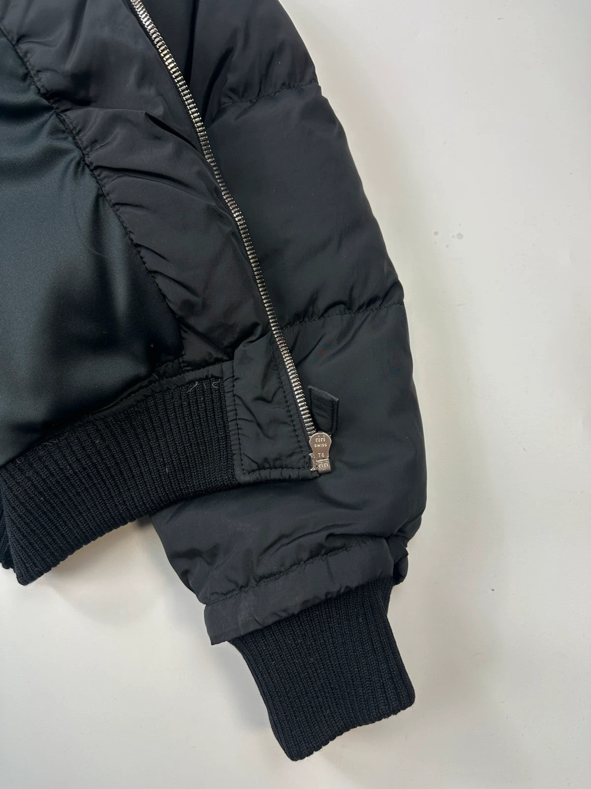 Prada black cropped bomber puffer jacket with logo detailing and vintage 90s design.