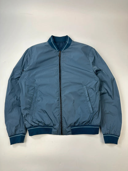 Prada blue reversible bomber jacket, nylon material, featuring logo and sleek minimalist design.