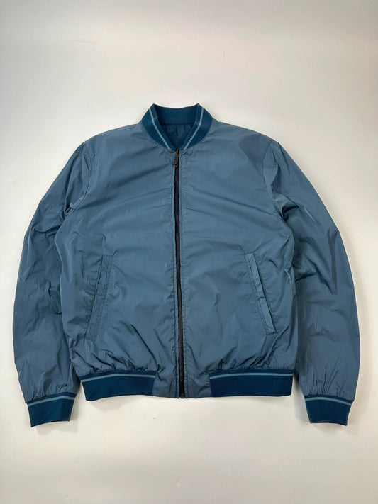 Prada blue reversible bomber jacket, nylon material, featuring logo and sleek minimalist design.