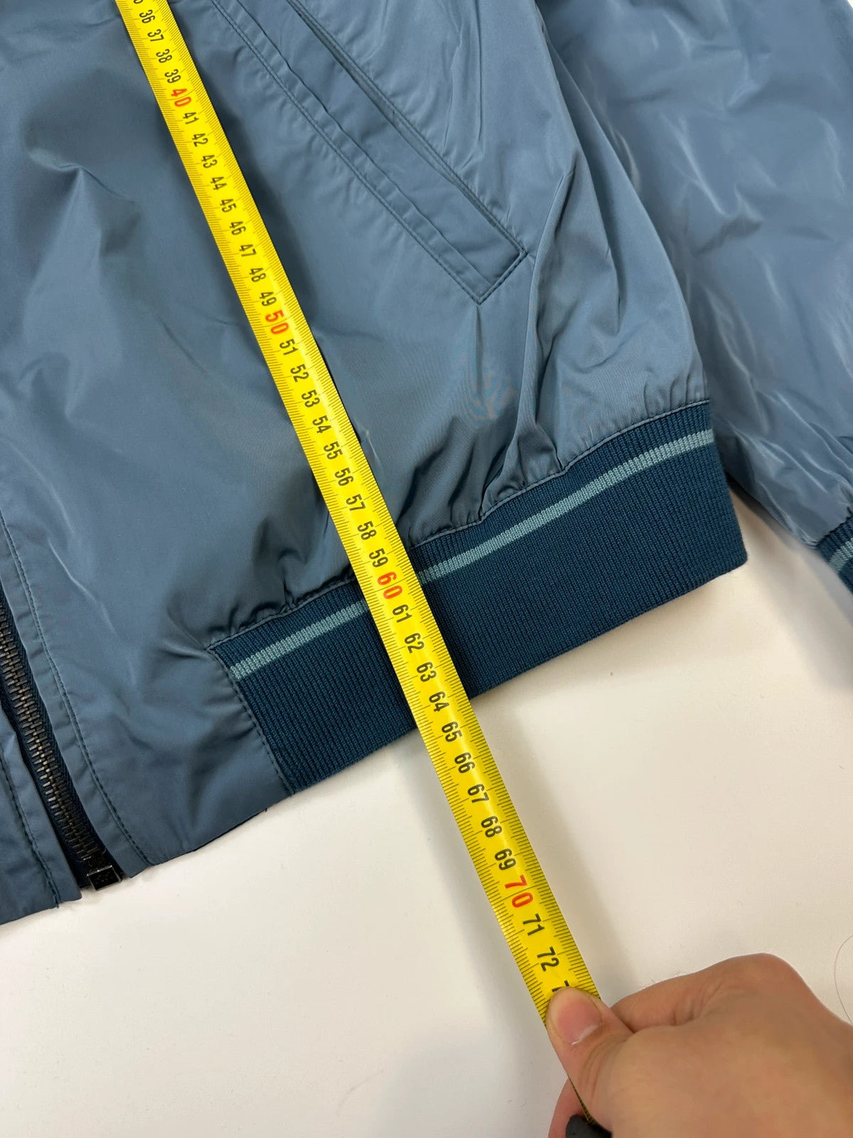 Prada blue reversible bomber jacket, nylon material, featuring logo and sleek minimalist design.