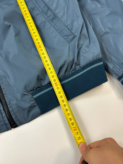 Prada blue reversible bomber jacket, nylon material, featuring logo and sleek minimalist design.