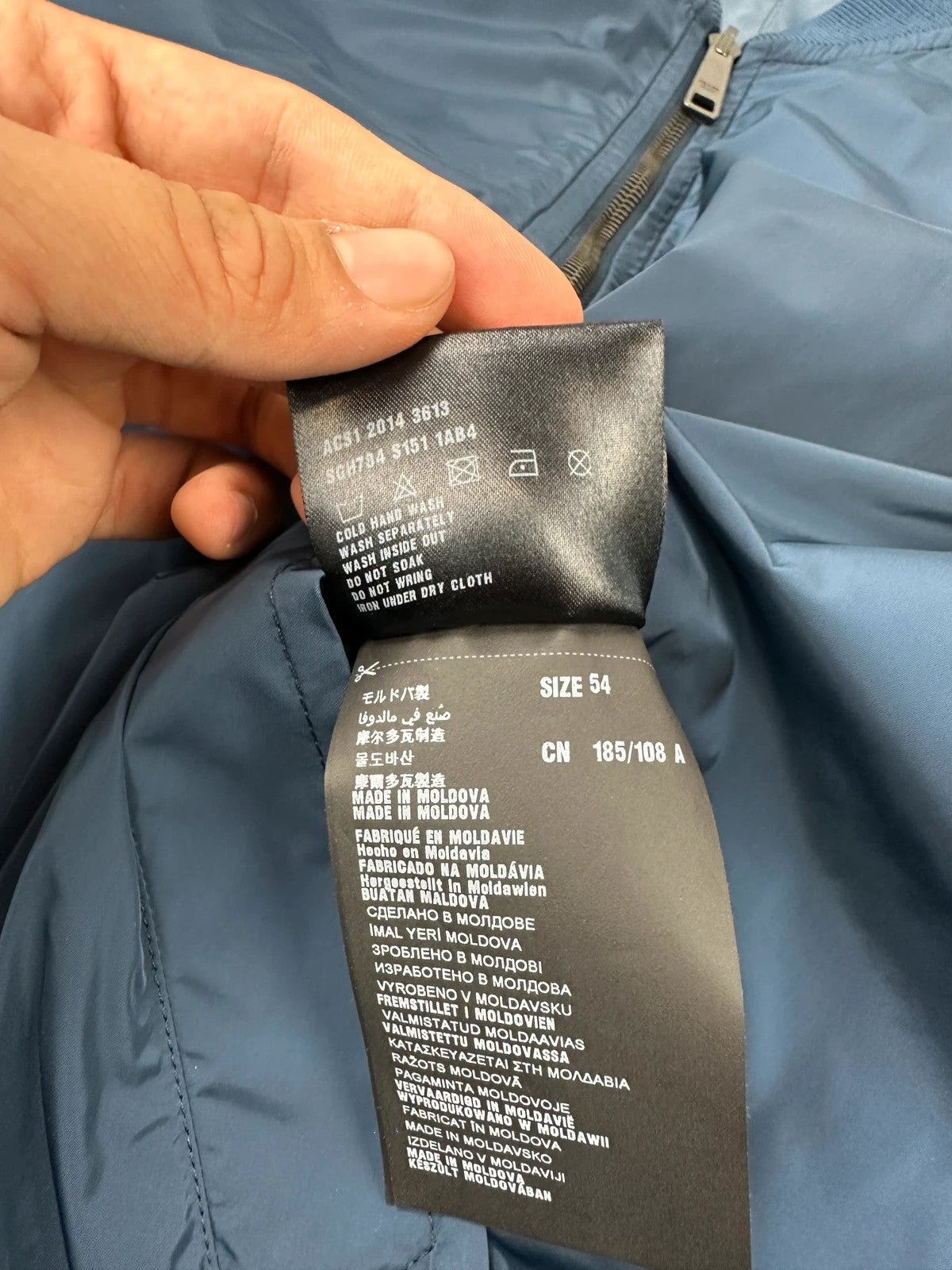 Prada blue reversible bomber jacket, nylon material, featuring logo and sleek minimalist design.