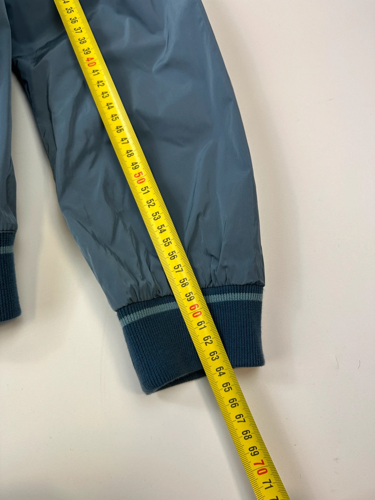 Prada blue reversible bomber jacket, nylon material, featuring logo and sleek minimalist design.